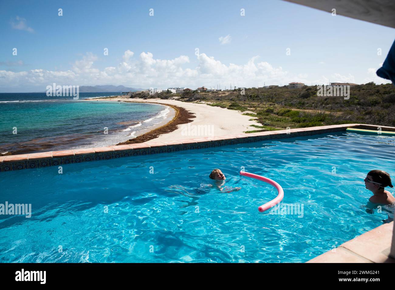 Brüder schwimmen im Infinity Pool neben dem Caribbean Beach Stockfoto