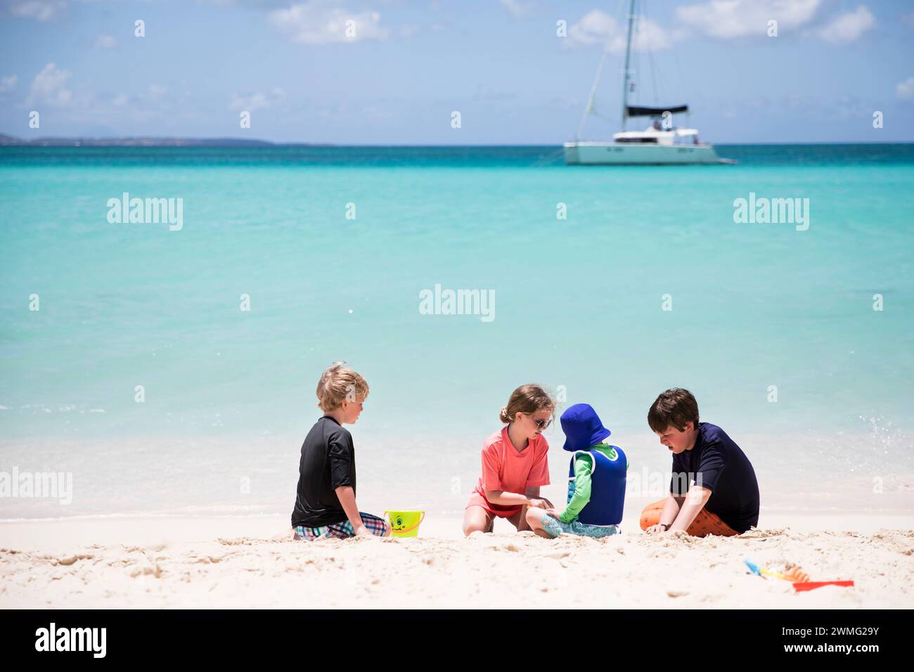 Big Family of Geschwister baut gemeinsam Sandcastle am Caribbean Beach Stockfoto