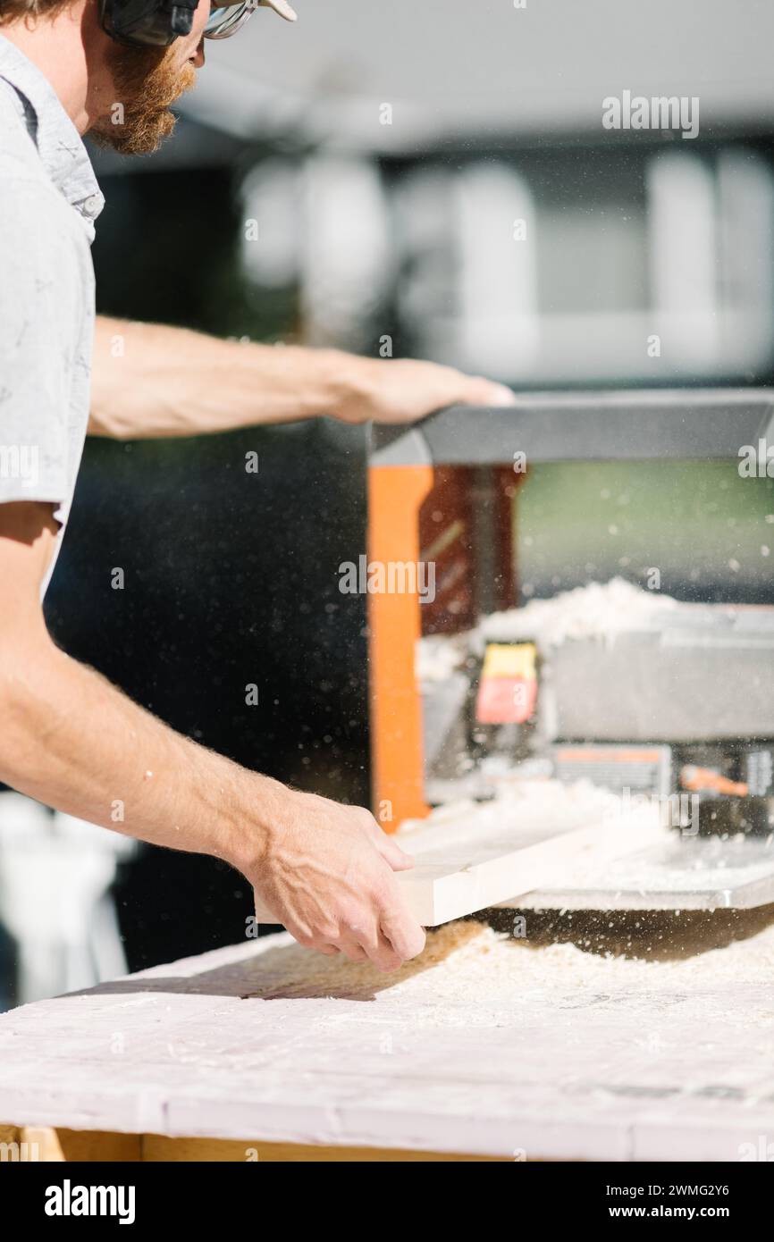 Zimmermann formt Holz mit Hobel präzise. Stockfoto