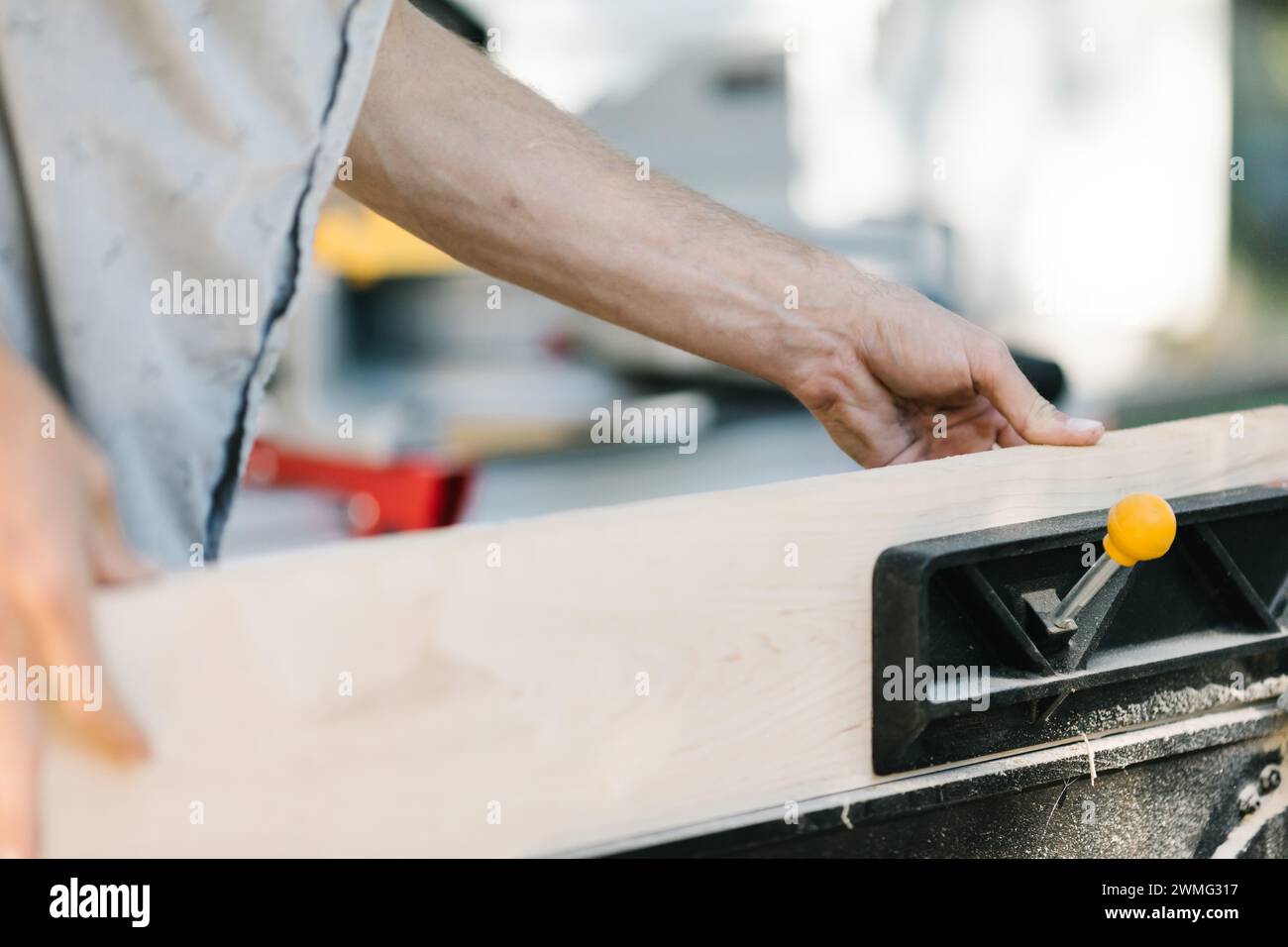 Die Hände des Zimmermanns bedienen einen Holzhobel. Stockfoto