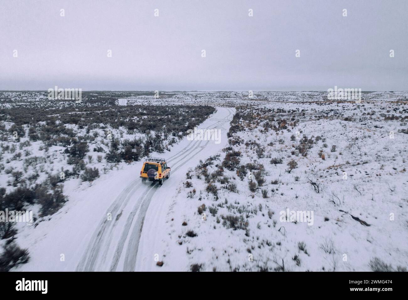 Ein Geländewagen fährt an einem bewölkten Tag durch den Schnee. Stockfoto