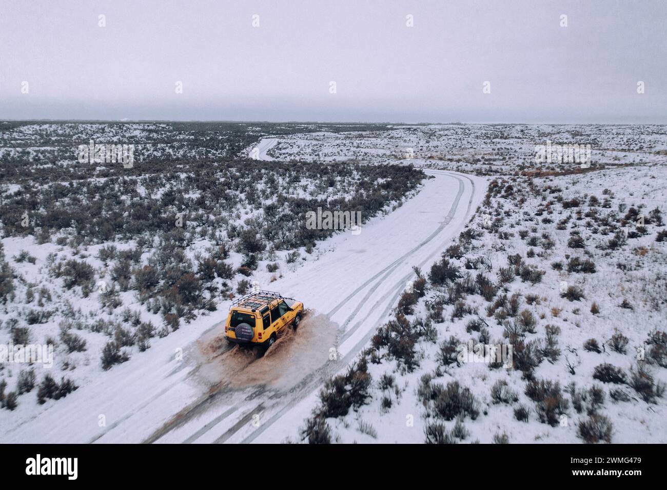 Ein Geländewagen fährt an einem bewölkten Tag durch den Schnee. Stockfoto