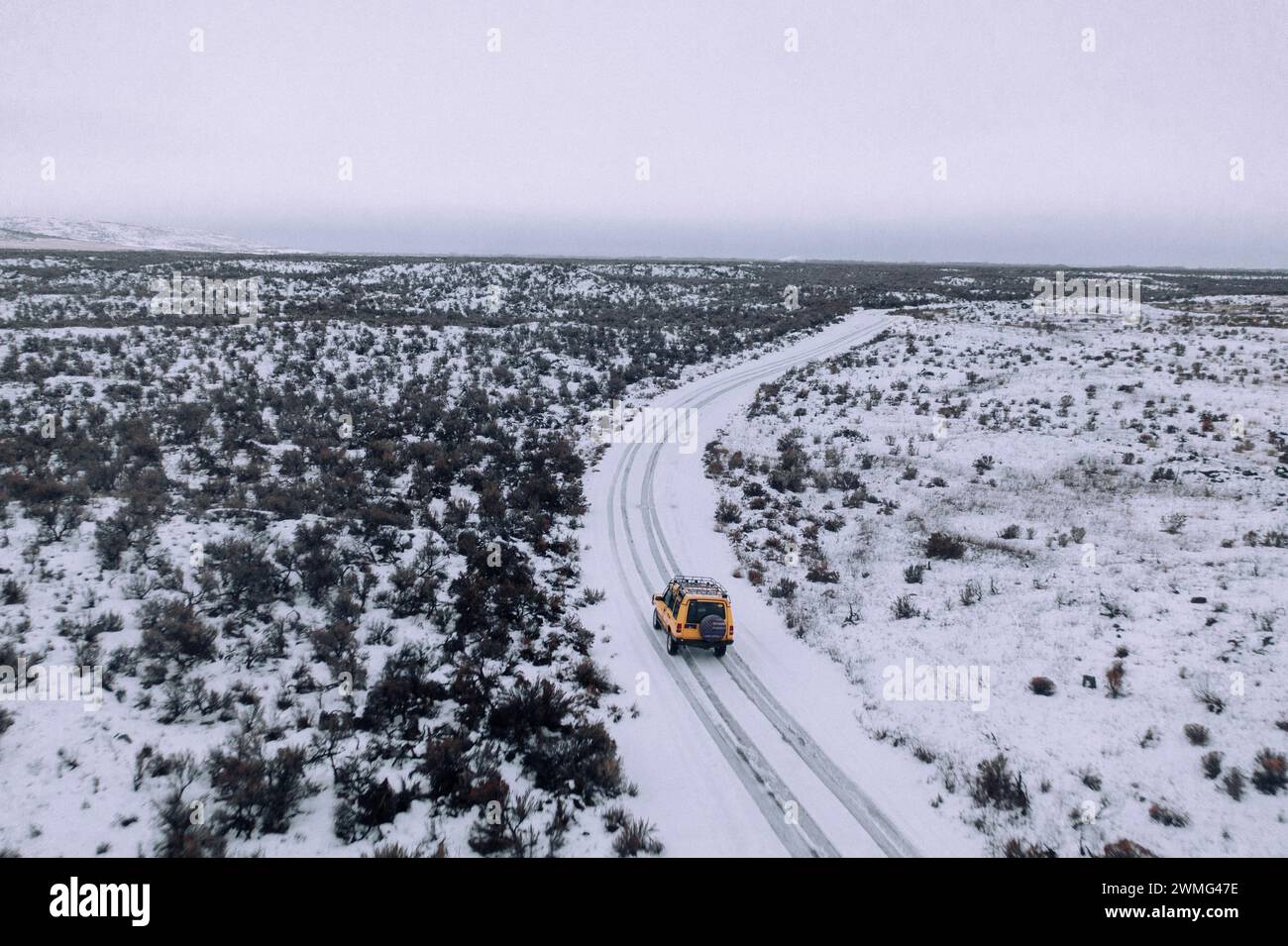 Ein Geländewagen fährt an einem bewölkten Tag durch den Schnee. Stockfoto