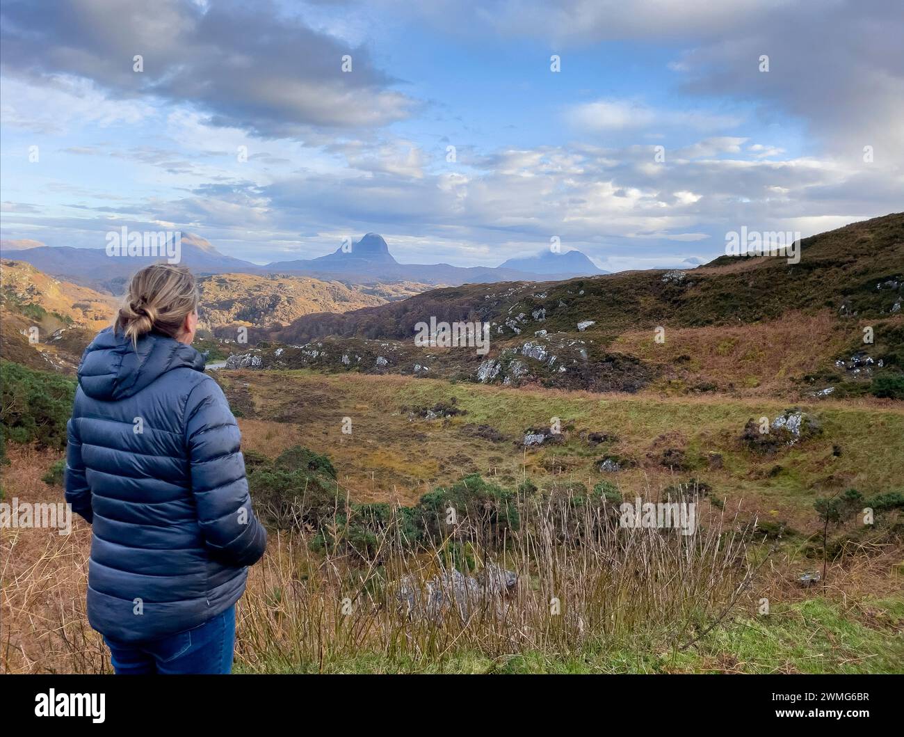 Herbstliche Farben der schottischen Moorlandschaft mit Frau, die die Aussicht betrachtet, Berge im Hintergrund Stockfoto