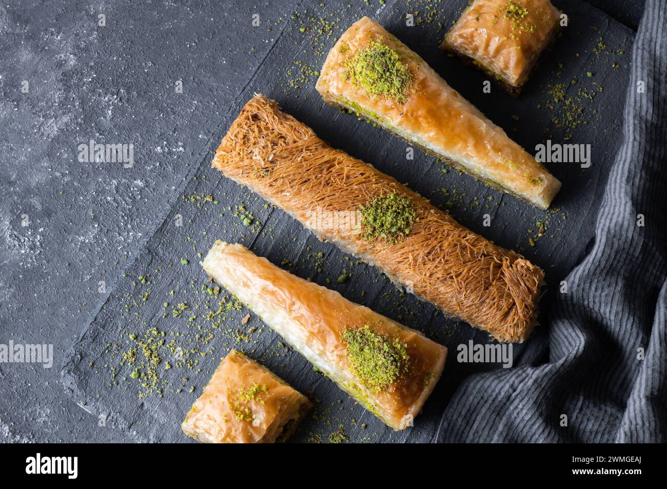 Traditionelles türkisches Dessertkonzept, Kadayif, Karottenscheibe, Vorspeisenbaklava mit Pistazien auf rustikalem Hintergrund Stockfoto