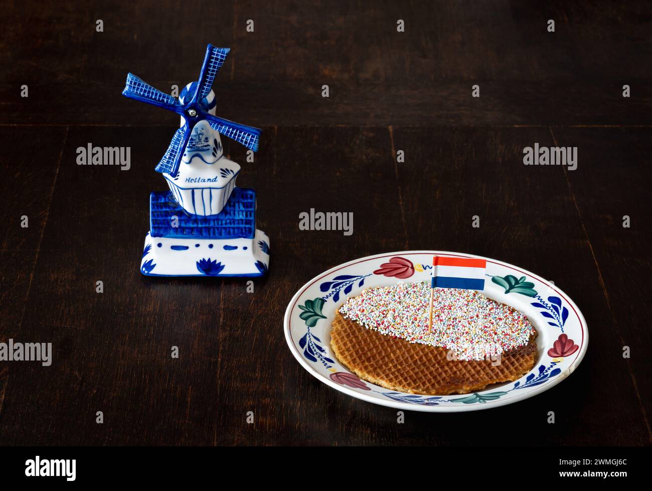 Eine Stroopwafel mit Streuseln und niederländischer Flagge auf dem Teller, ein runder Waffelkeks, der in den Niederlanden beliebt ist Stockfoto
