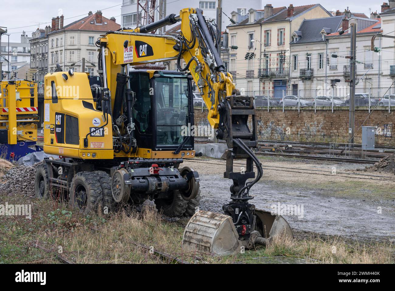 Nancy, Frankreich – Schwerpunkt auf einem gelben Radbagger CAT M323F auf der Baustelle für die Erneuerung einer Eisenbahnstrecke. Stockfoto