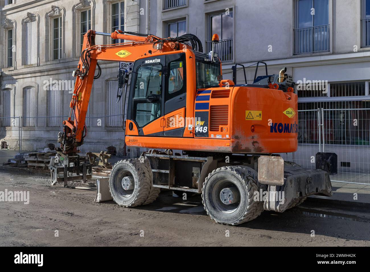 Nancy, Frankreich – Schwerpunkt auf einem orangefarbenen Radbagger Komatsu PW148-11 auf der Baustelle für Straßenarbeiten. Stockfoto