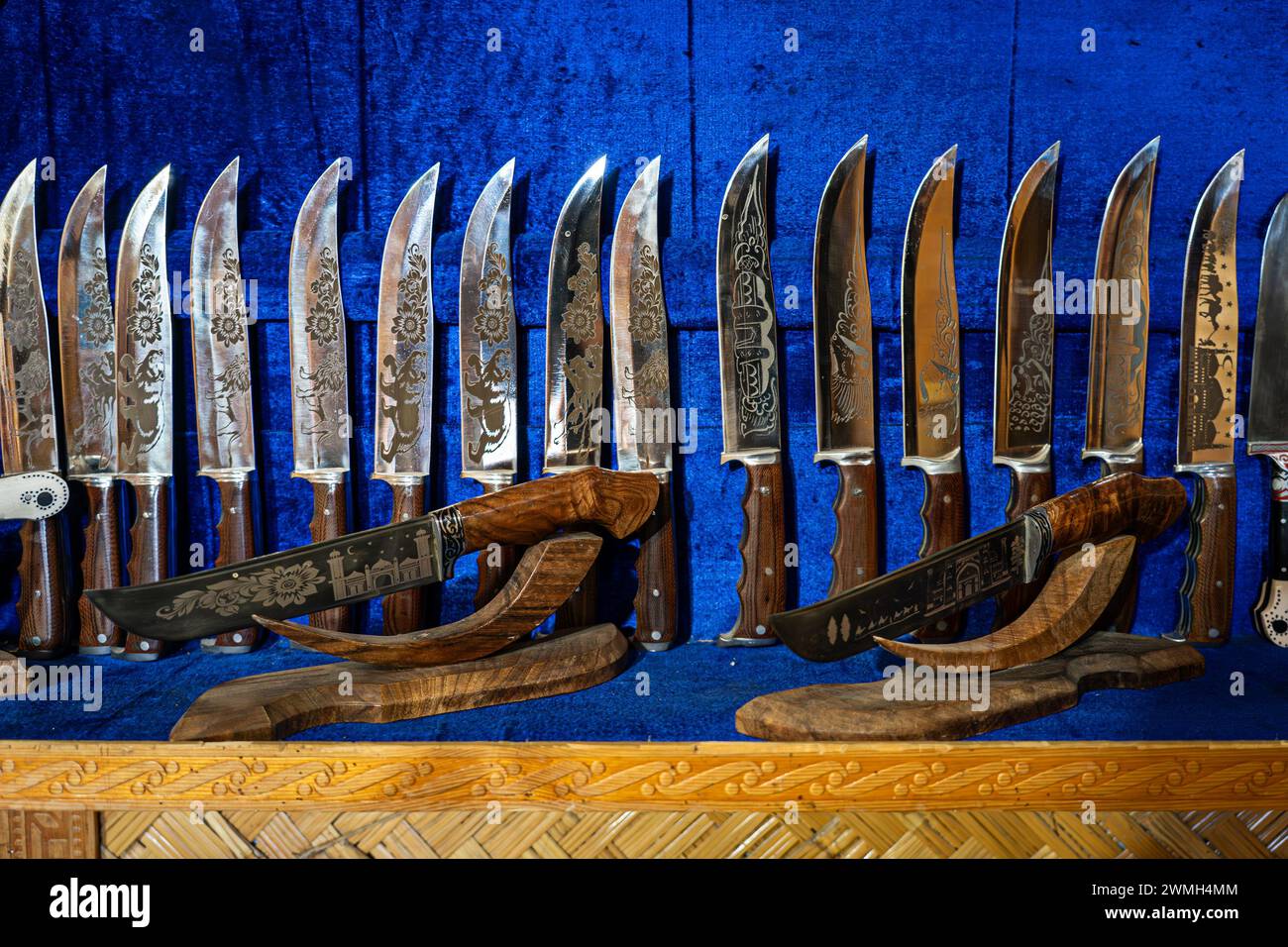 Messer aus Stahl auf der Theke im Geschäft auf blauem Hintergrund. Das Pchak ist ein traditionelles usbekisches Messer mit einer gebogenen Form. Stockfoto