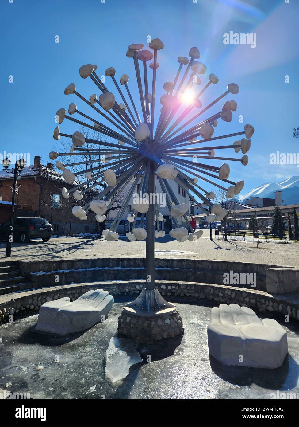 Ein interessantes Gebäude in der Altstadt von Bansko mit verschneiten Pirin-Bergen im Hintergrund, aufgenommen in Bulgarien Stockfoto