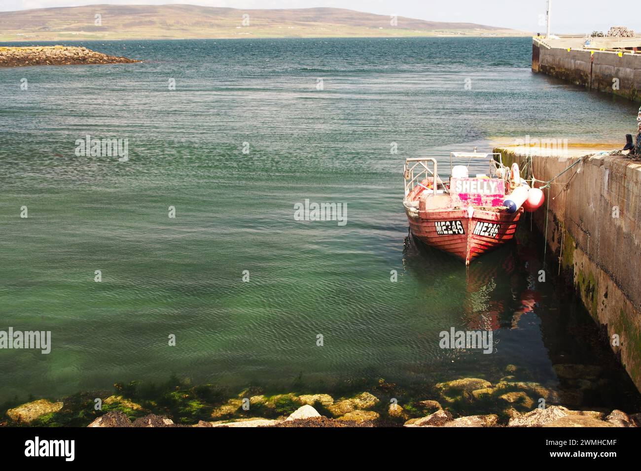 Ein kleines Fischerboot liegt neben dem Tingwall Pier, Orkney, Schottland, Großbritannien Stockfoto
