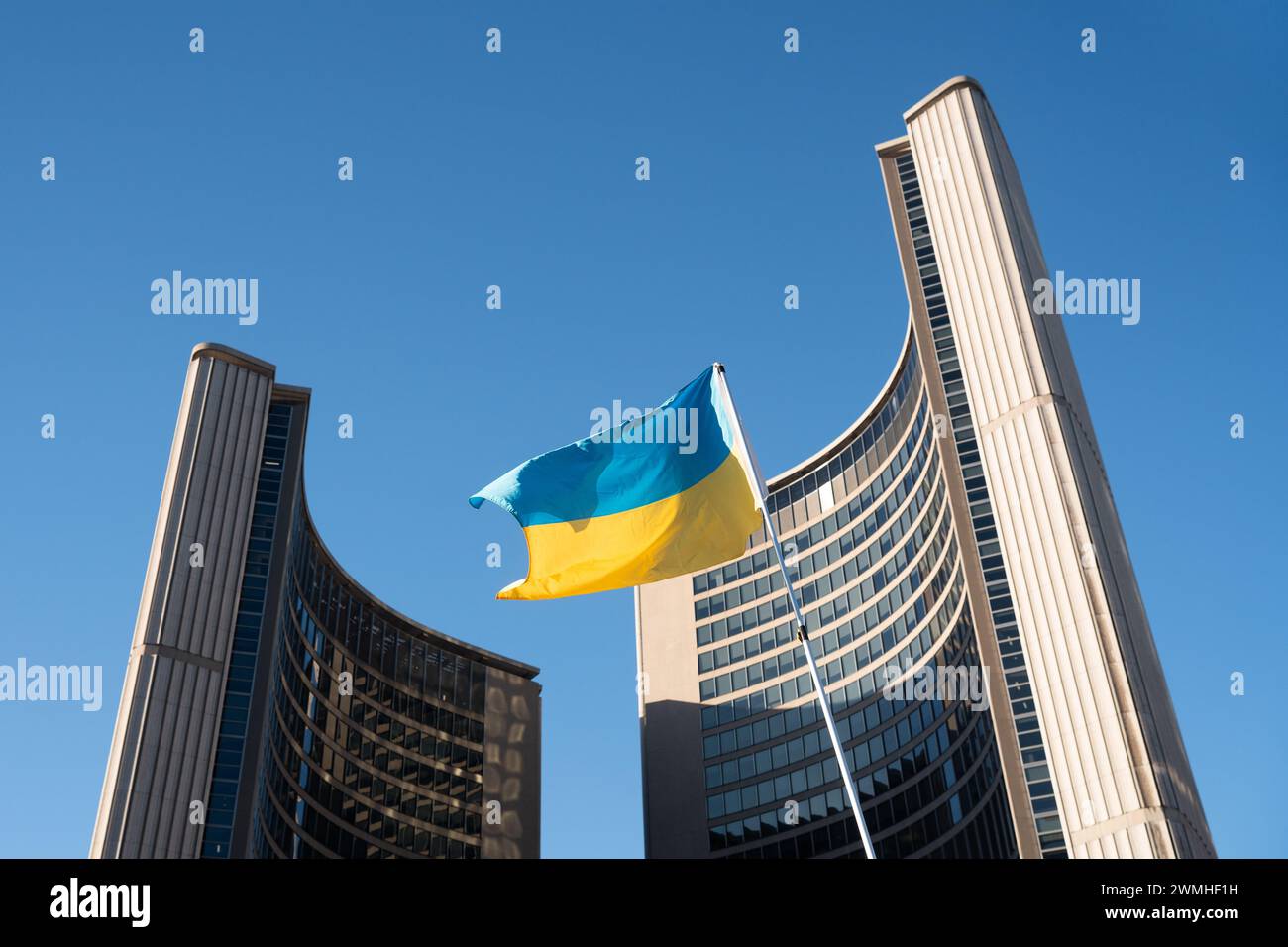 Eine ukrainische Flagge fliegt vor dem Rathaus von Toronto während der Demonstration der Ukraine, die zwei Jahre seit Russlands Invasion markiert. Stockfoto