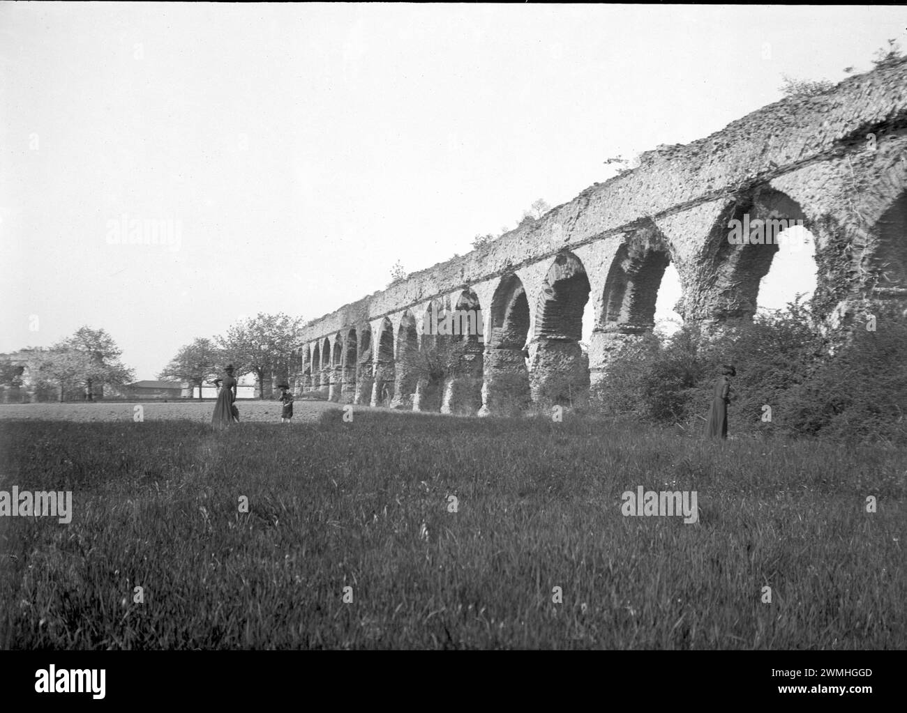 Eine Gruppe von Männern und Frauen neben den Ruinen einer römischen Reichsbrücke im Südosten von Fr. Anfang des 20. Jahrhunderts. Altes Foto von Glasplatte restauriert. Stockfoto