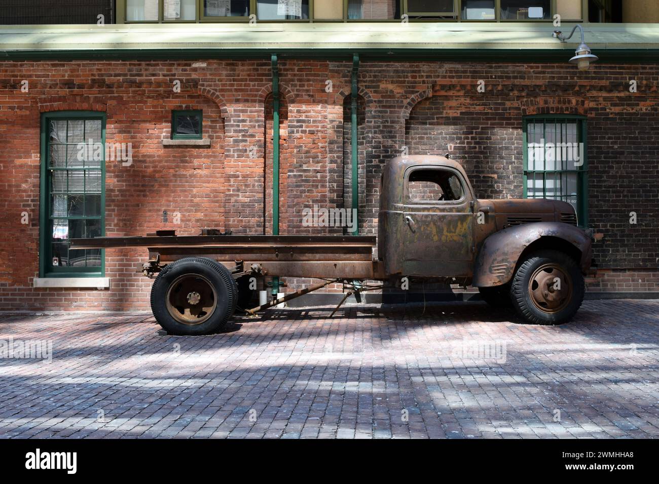 Rusty Vintage 1940er Jahre American Dodge Platbed Truck neben einer Brick Wall im Historic Distillery District, Toronto, Ontario, Kanada Stockfoto