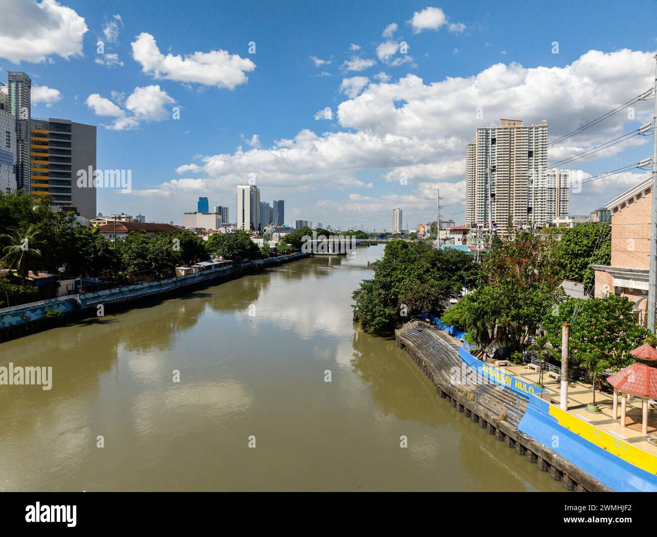 Fluss zwischen Wohngebiet in Metro Manila. Blauer Himmel und Wolken. Philippinen. Stockfoto