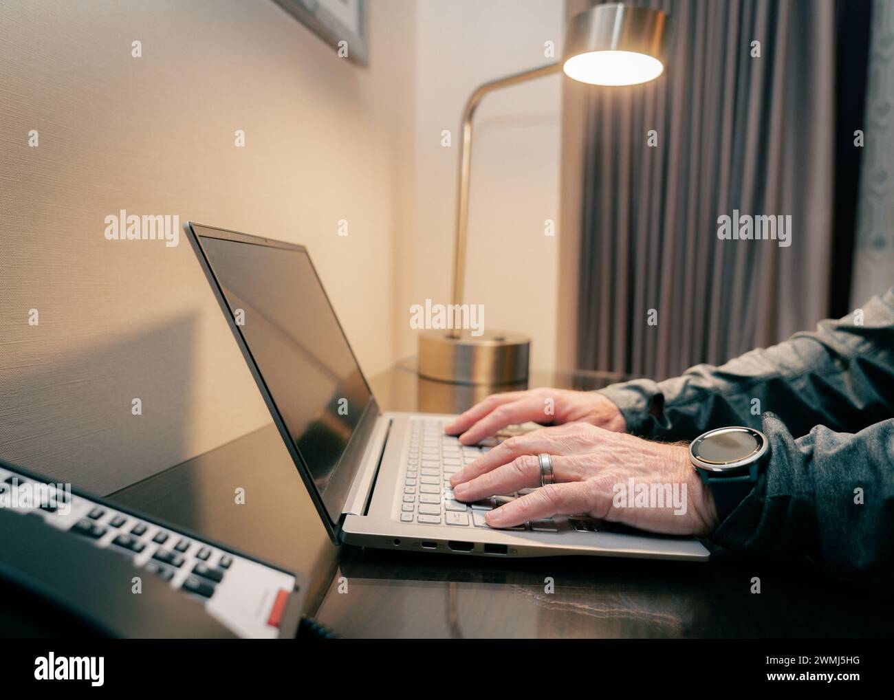 Nahaufnahme der Hände eines Mannes, die an einem Schreibtisch am Computer tippen Stockfoto