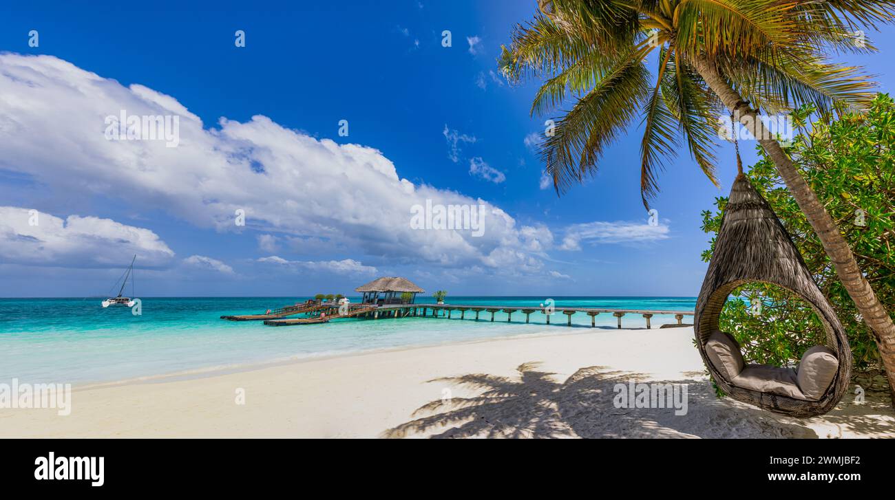 Tropisches Strandpanorama als Sommerlandschaft zum Entspannen mit Strandschaukel oder Hängematte an Palmen über weißem Sand Meer Strandbanner. Fantastischer Strandurlaub Stockfoto