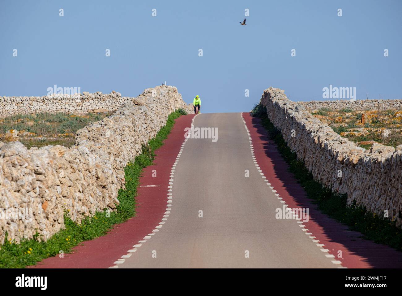 Einsame Radfahrerin, Punta Nati Cape, Ciutadella, Menorca, Balearen, Spanien Stockfoto