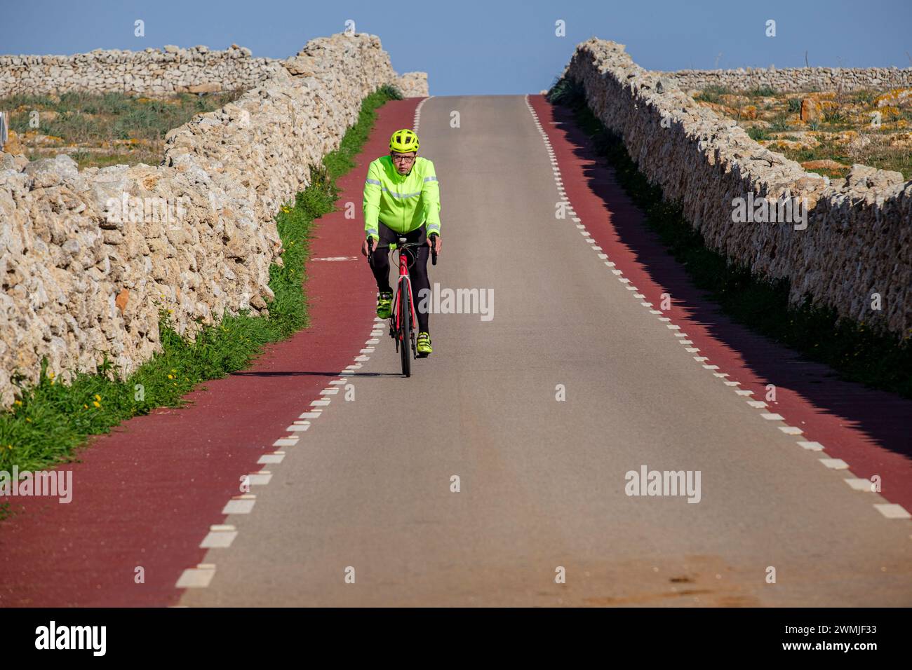 Einsame Radfahrerin, Punta Nati Cape, Ciutadella, Menorca, Balearen, Spanien Stockfoto