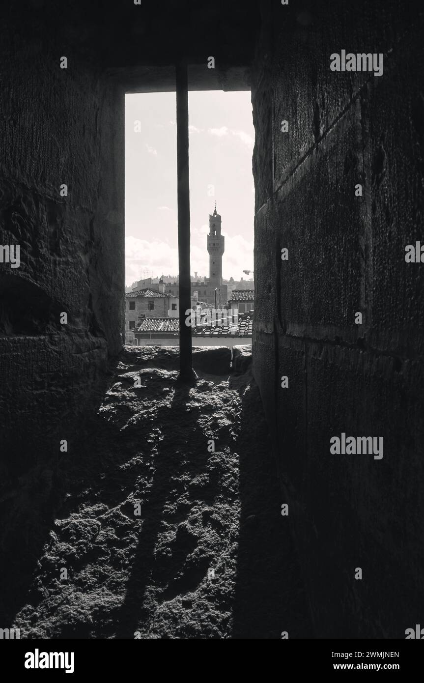 06-11-2023 Florenz, Italien - der Turm des Palazzo Vecchio mit Blick durch das Fenster des Campanile di Giotto, eine faszinierende Perspektive Stockfoto