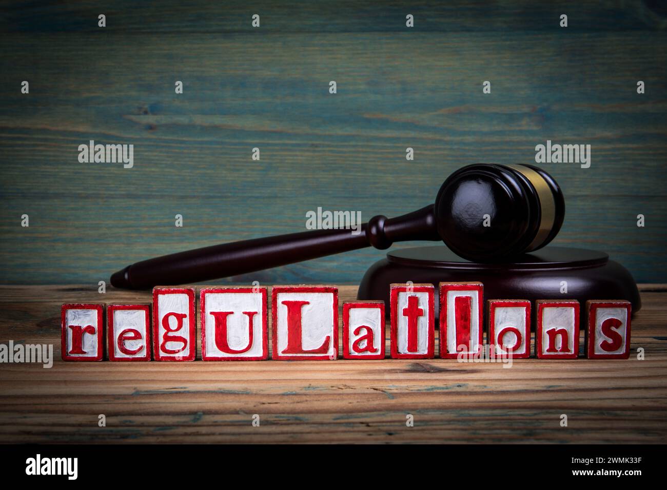 VORSCHRIFTEN. Rote Buchstaben und richterlicher Hammer auf hölzernem Hintergrund. Recht und Gerechtigkeit. Stockfoto