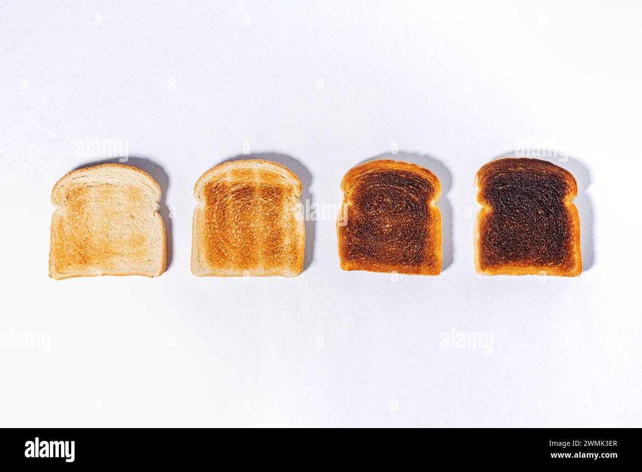 Verschiedene Toaststufen, geröstete quadratische Brotscheiben, Blick von oben Stockfoto