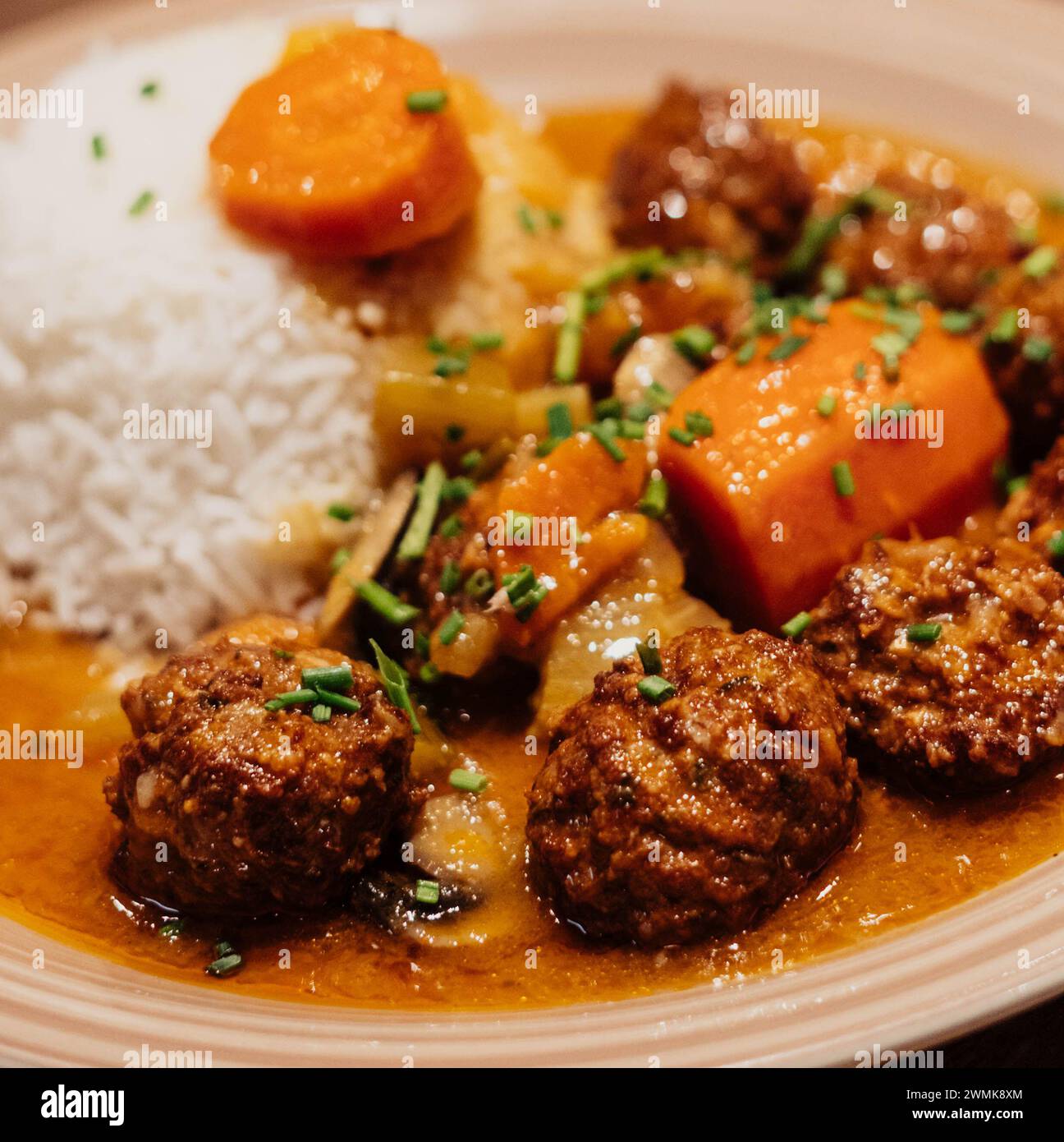 Teller mit Fleischbällchen mit Reis und Karotten in Sauce Stockfoto