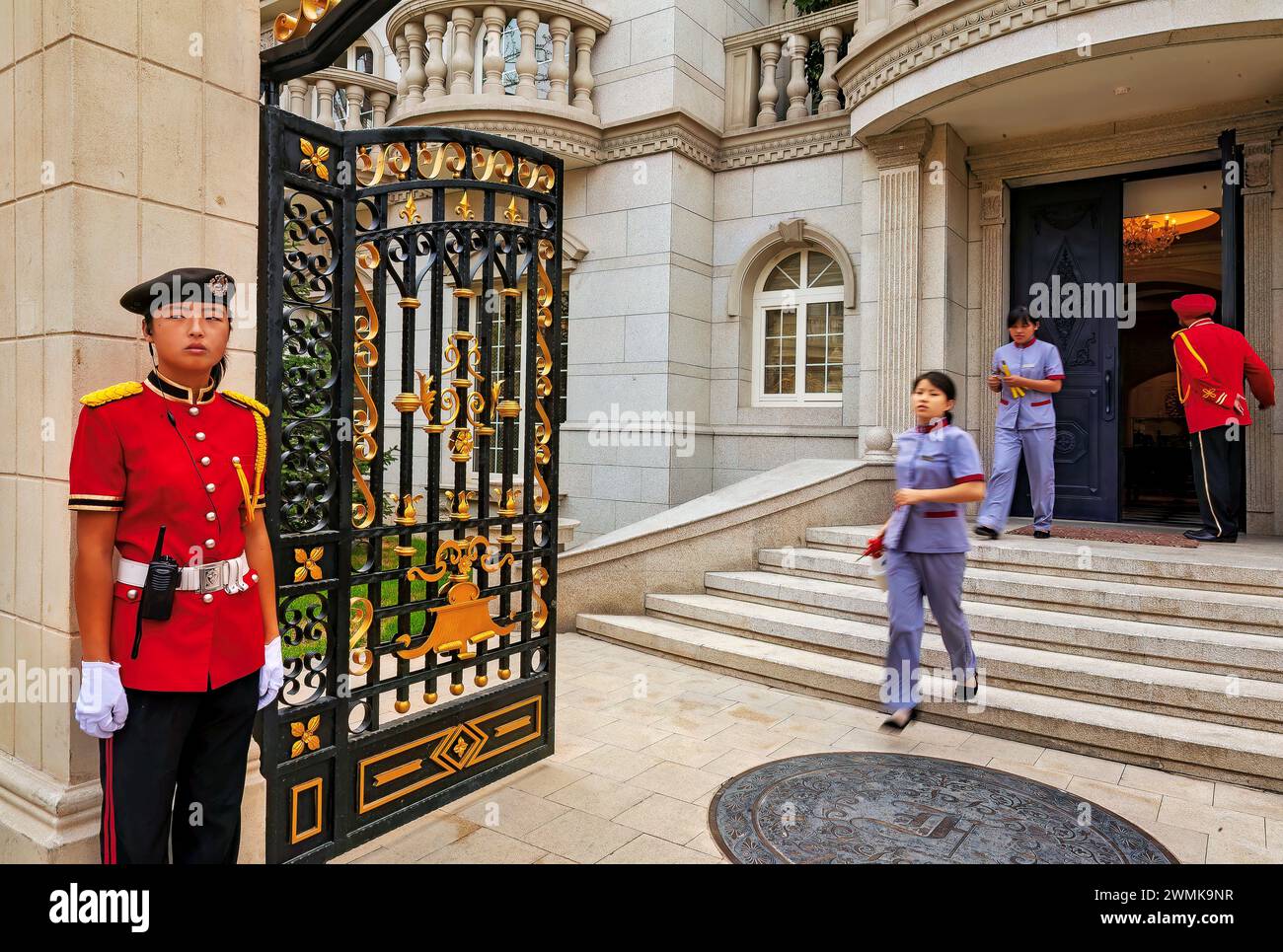 Reinigungspersonal und Wachen in roter Uniform in einer Villa im Palais de Fortune außerhalb Pekings, Volksrepublik China Stockfoto