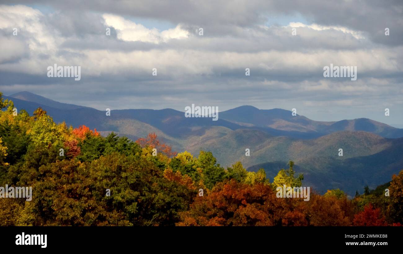 Herbstszene in den Blue Ridge Mountains mit leuchtendem Herbstlaub und Wolken, die Schatten auf die Bergrücken in der Ferne werfen, im Norden von Kalifornien... Stockfoto