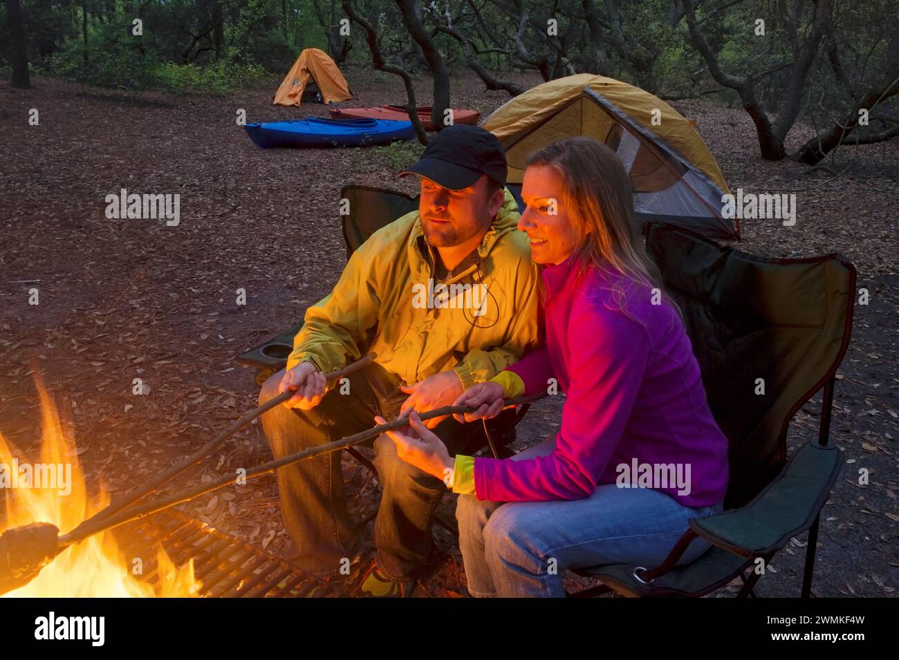 Paare genießen ein Feuer und rösten Marshmallows während des Campingens; Virginia Beach, Virginia, Vereinigte Staaten von Amerika Stockfoto