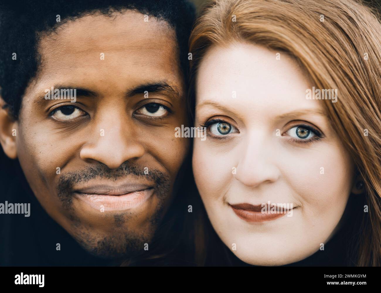 Nahaufnahme eines Paares mit gemischter Rasse, das in die Kamera schaut und während eines Familienausflugs im Herbst in einem Stadtpark wertvolle Zeit miteinander verbringt Stockfoto