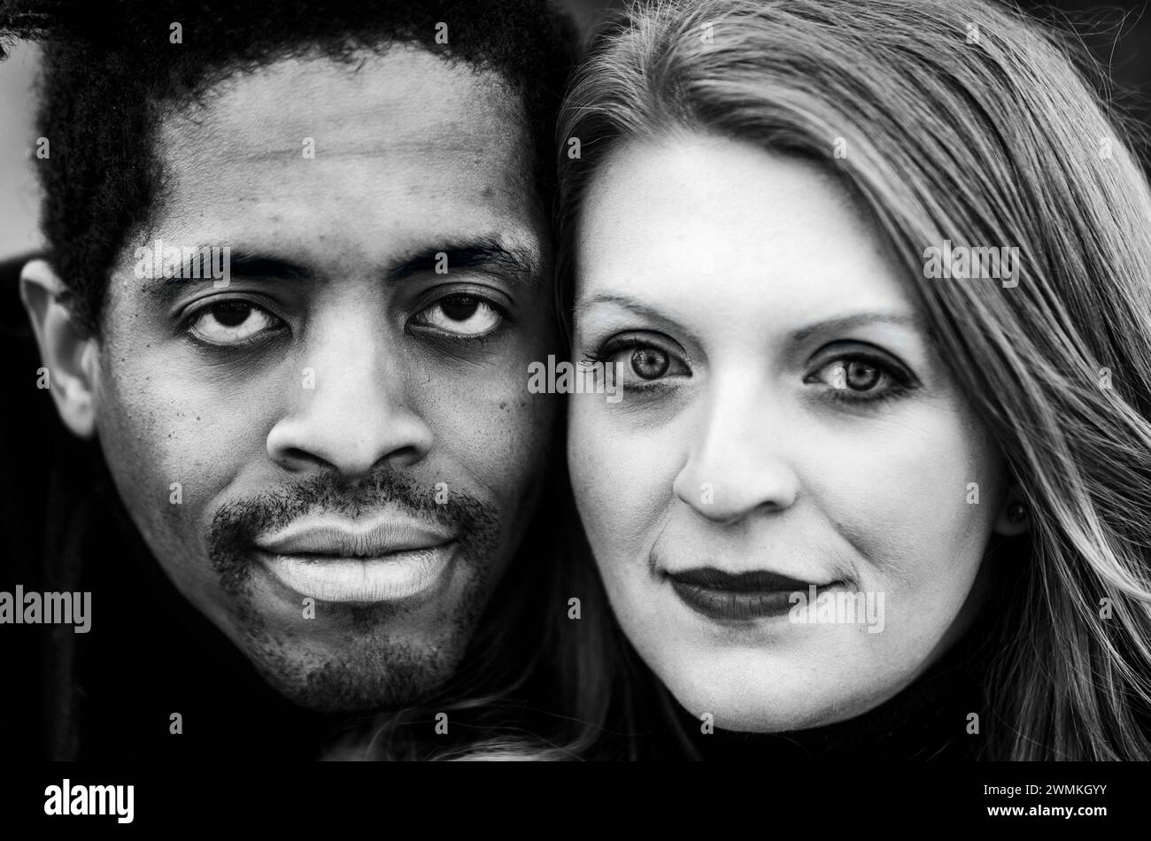 Nahaufnahme eines Paares mit gemischter Rasse, das in die Kamera schaut und während eines Familienausflugs im Herbst in einem Stadtpark wertvolle Zeit miteinander verbringt Stockfoto