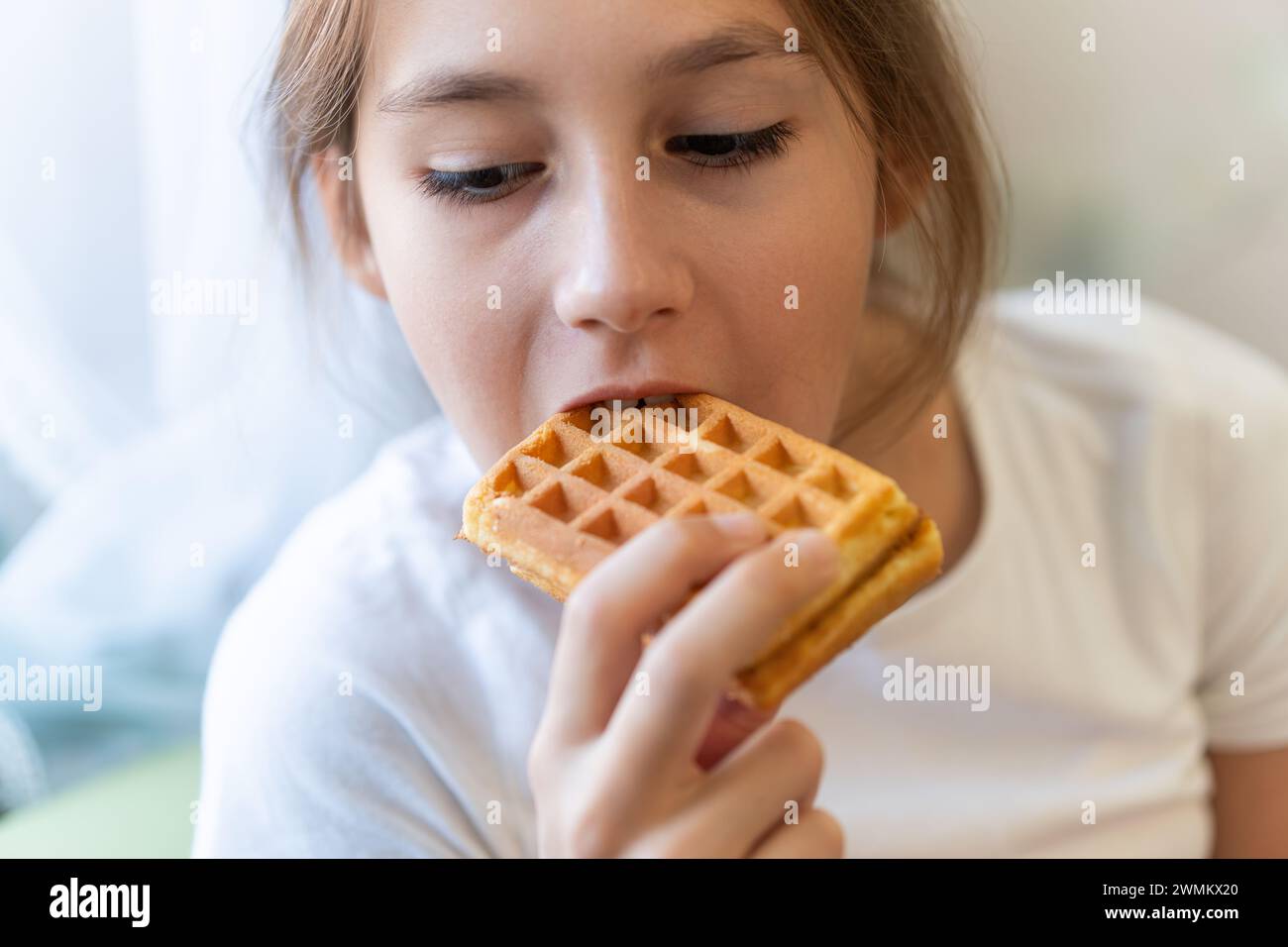 Bild von Girl Eats köstliche süße hausgemachte belgische Waffel genießt Lieblings-Dessert. Kalorienreiche Speisen. Diätbrechen Stockfoto