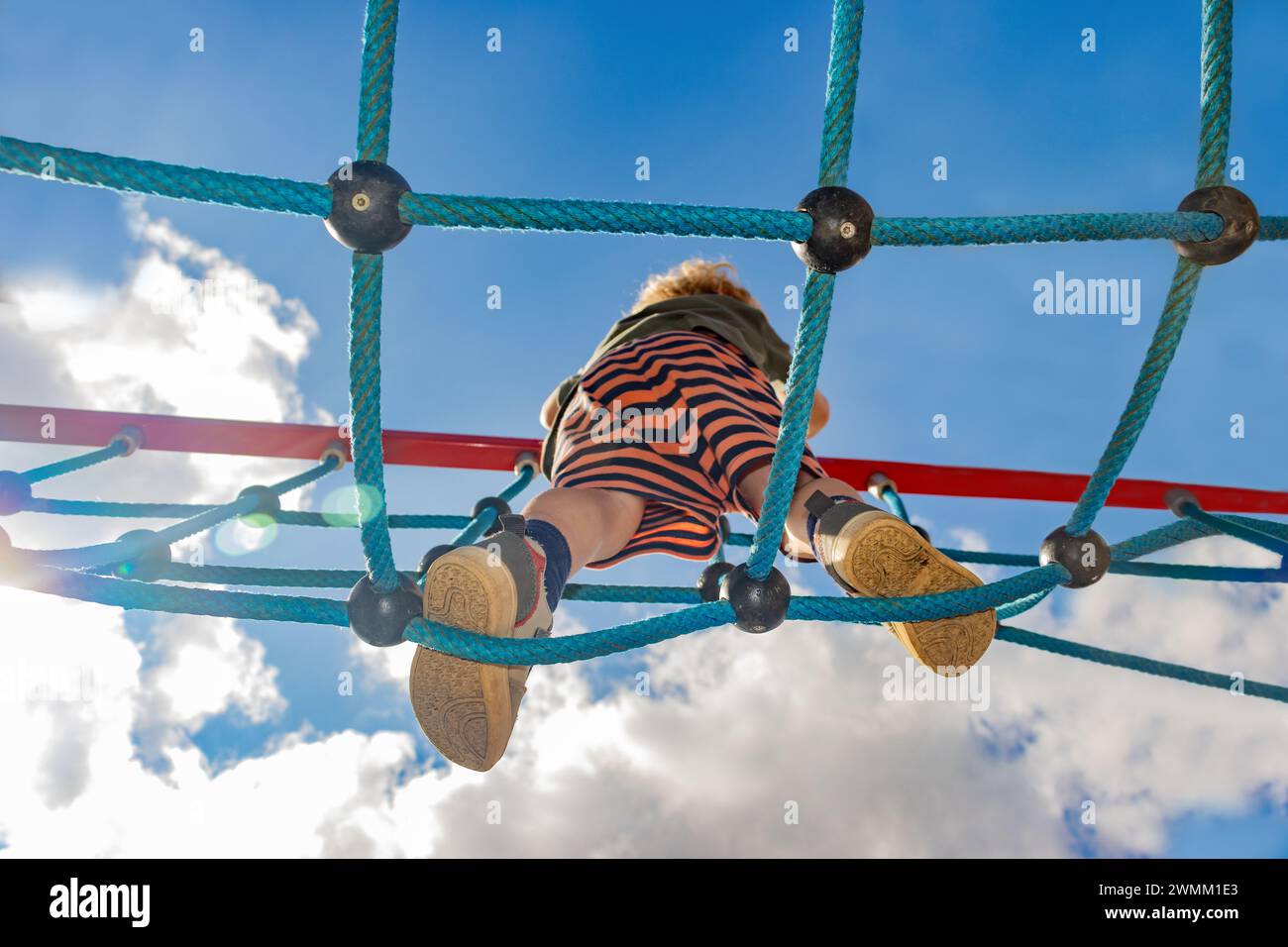 Ein kleiner Junge läuft auf einer Seilbrücke Stockfoto