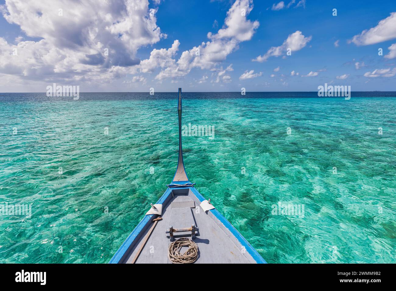 Hölzernes Segelboot in kristallklarer tropischer Lagunenbucht in der Nähe des Strandes einer einsamen exotischen Insel. Malediven Dhoni Boot, vertikales Panorama als Luxus Stockfoto
