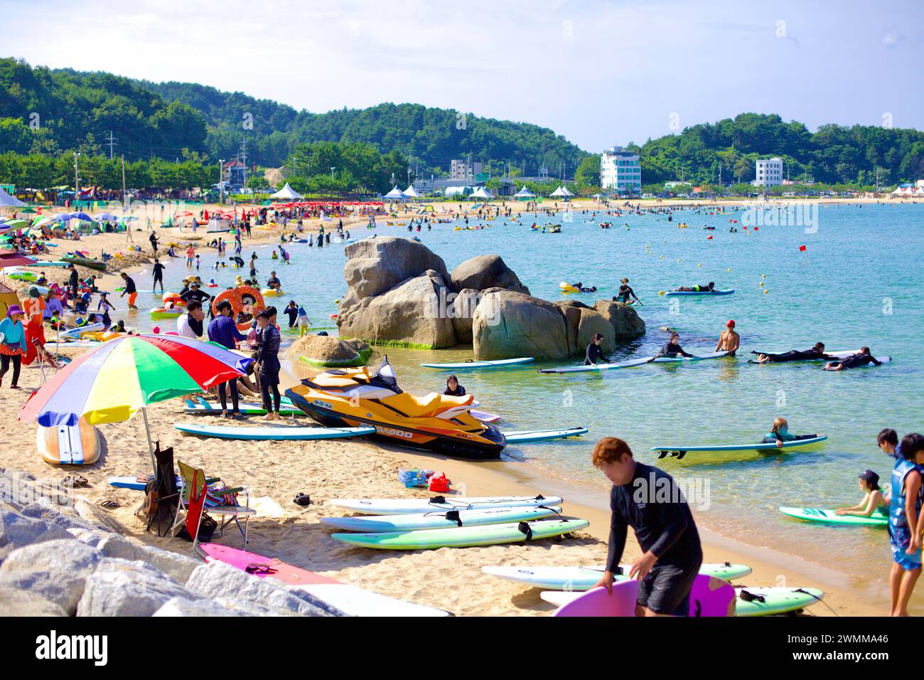 Yangyang County, Südkorea - 30. Juli 2019: Jukdo Beach ist voller Aktivitäten und bietet Surfer und Surfbretter im flachen, sandigen Wasser Stockfoto