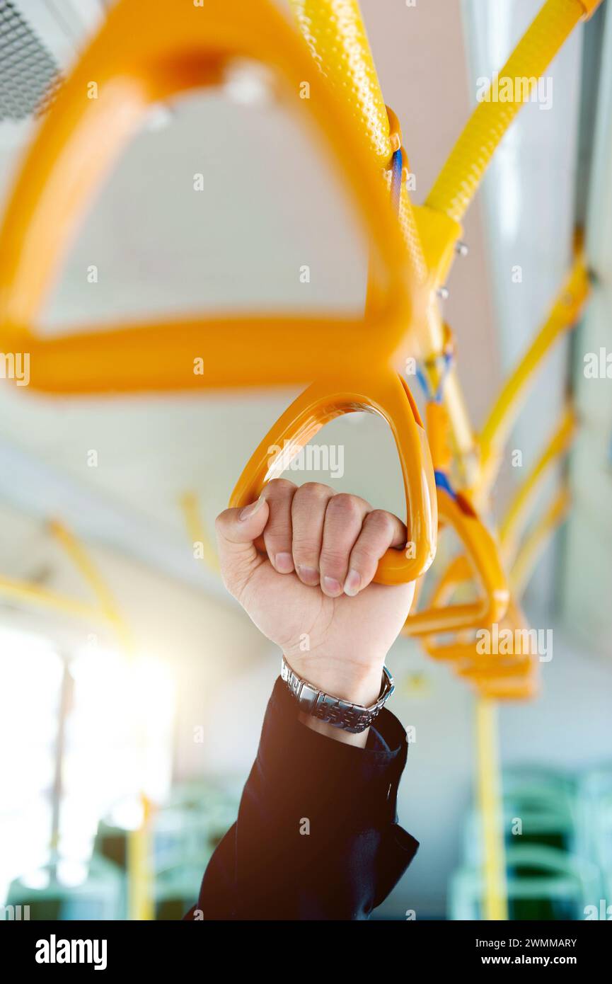Leute, die den Griff in einem Zug halten Stockfoto