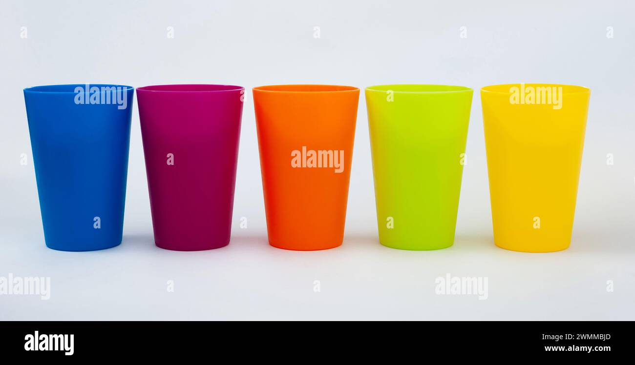 Kunststoffbecher verschiedener Farbe vor weißem Hintergrund Stockfoto