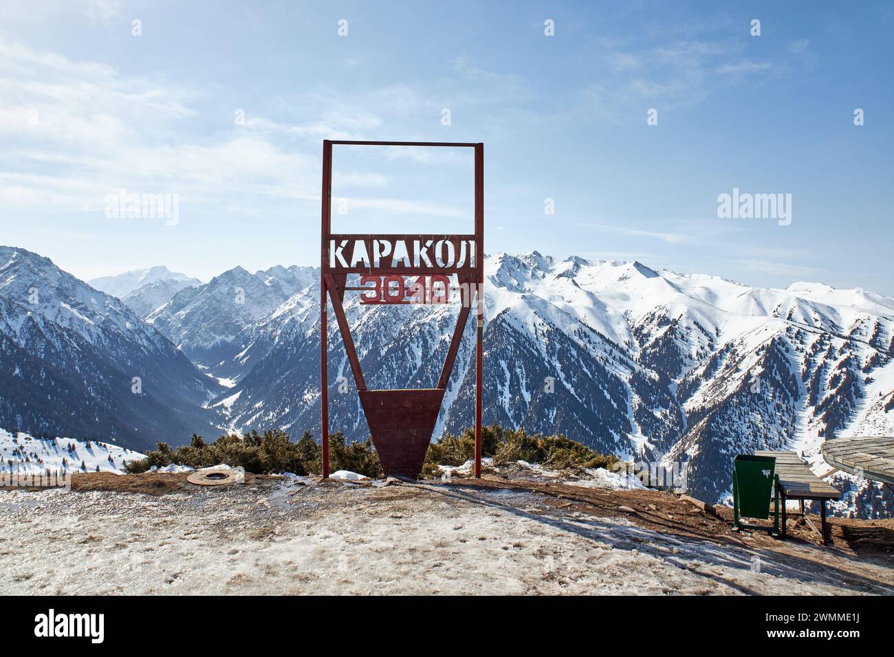 Skigebiet Karakol. Panoramablick auf die Winterberge in Kirgisistan. Schneebedeckte Gipfel, natürliche Landschaft an sonnigen Tagen. Erholungsgebiet und Schild auf der Spitze des Berges 3040 Meter über dem Meeresspiegel. Stockfoto