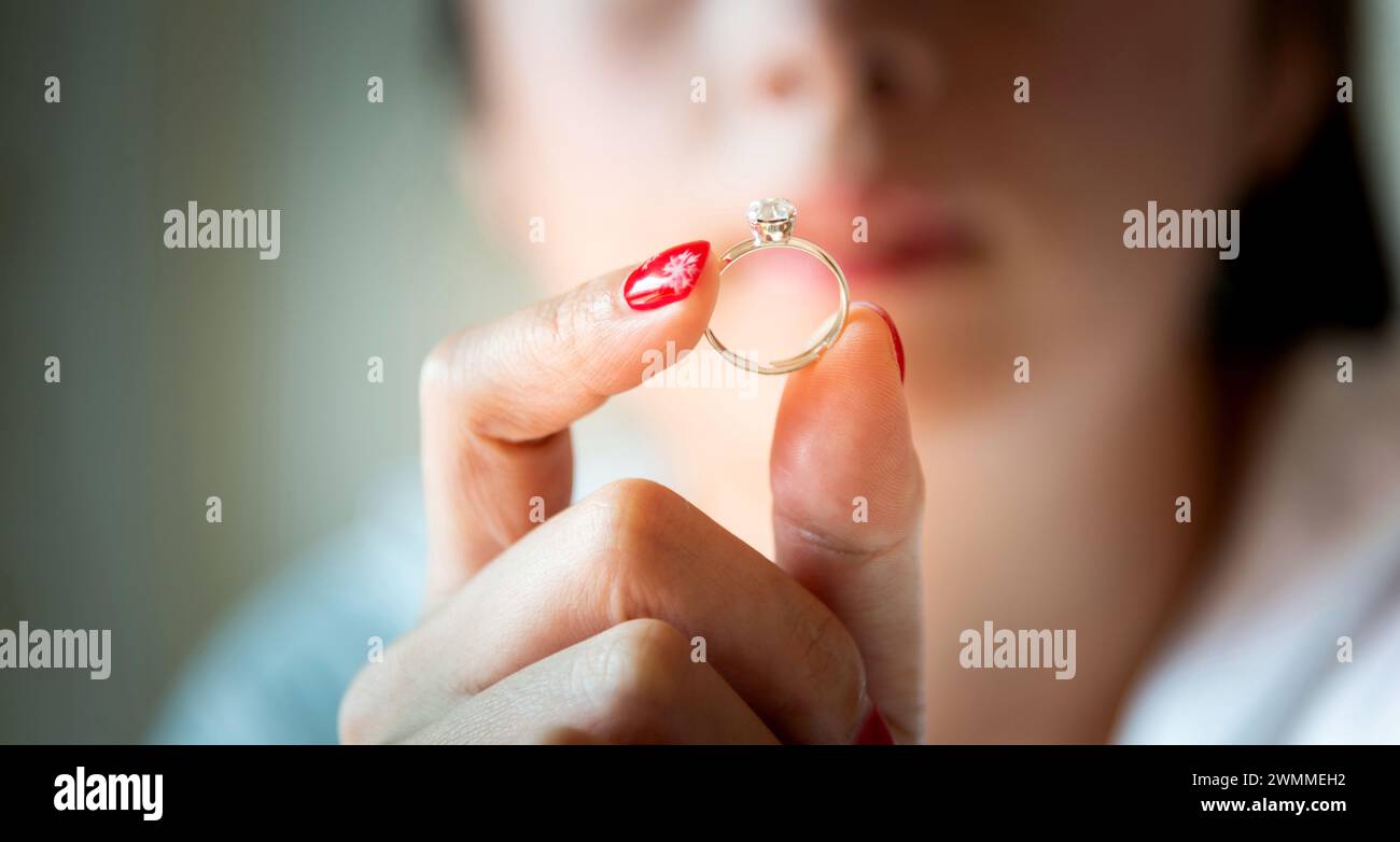 Junge Frau, die Ehering in der Hand zeigt Stockfoto