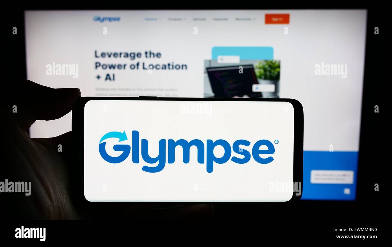 Person, die ein Mobiltelefon mit dem Logo des US-Unternehmens Glympse Inc. Vor der Unternehmenswebseite hält. Schwerpunkt auf dem Display des Telefons. Stockfoto