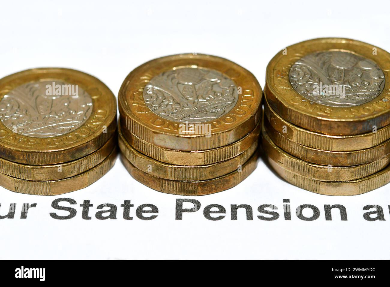 Säulen mit britischen 1-Pfund-Münzen auf einem Brief über die staatliche Pension. Renteneinkommenskonzept. Stockfoto