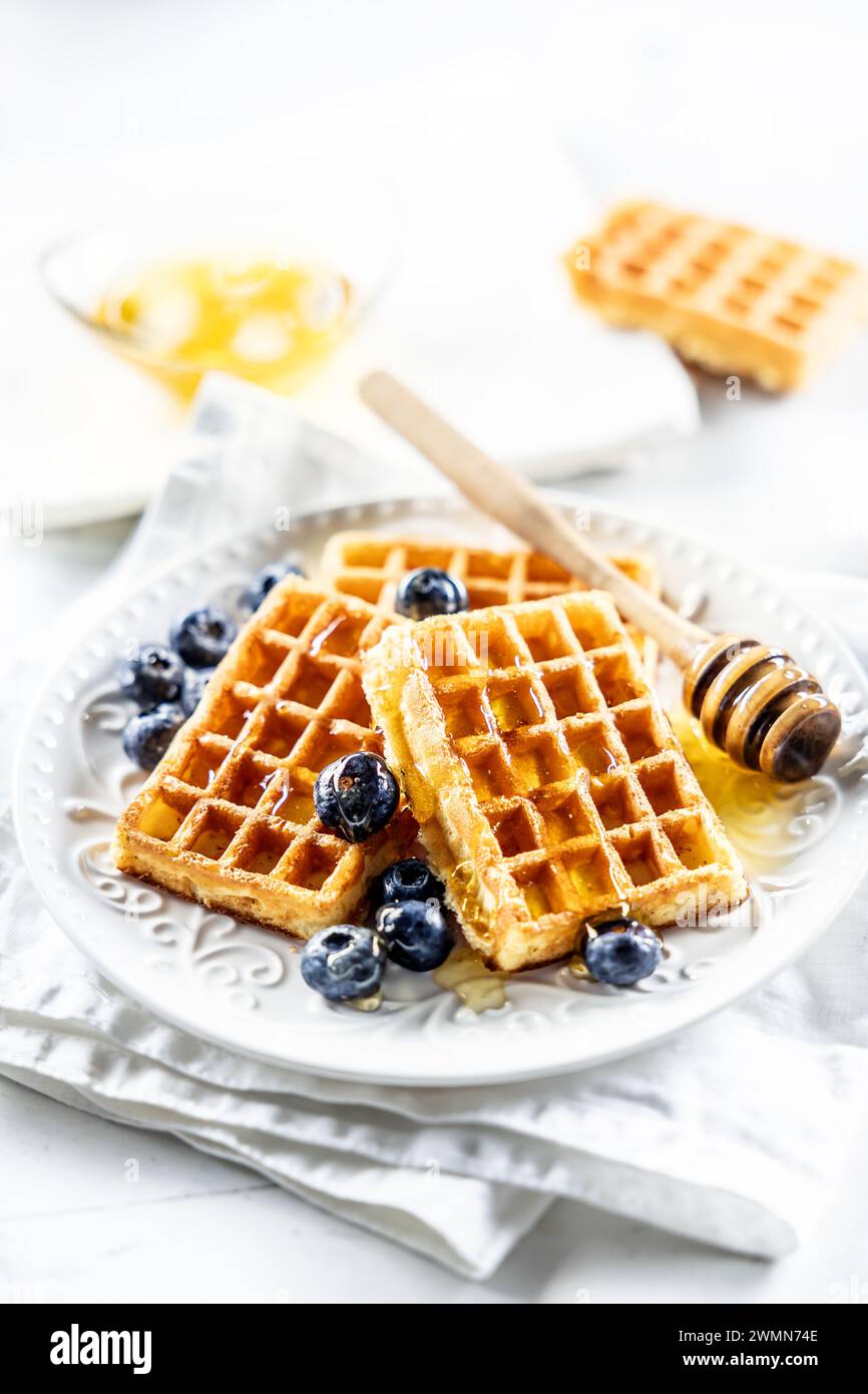 Süße und sehr leckere Waffeln mit Honig und Heidelbeeren. Stockfoto