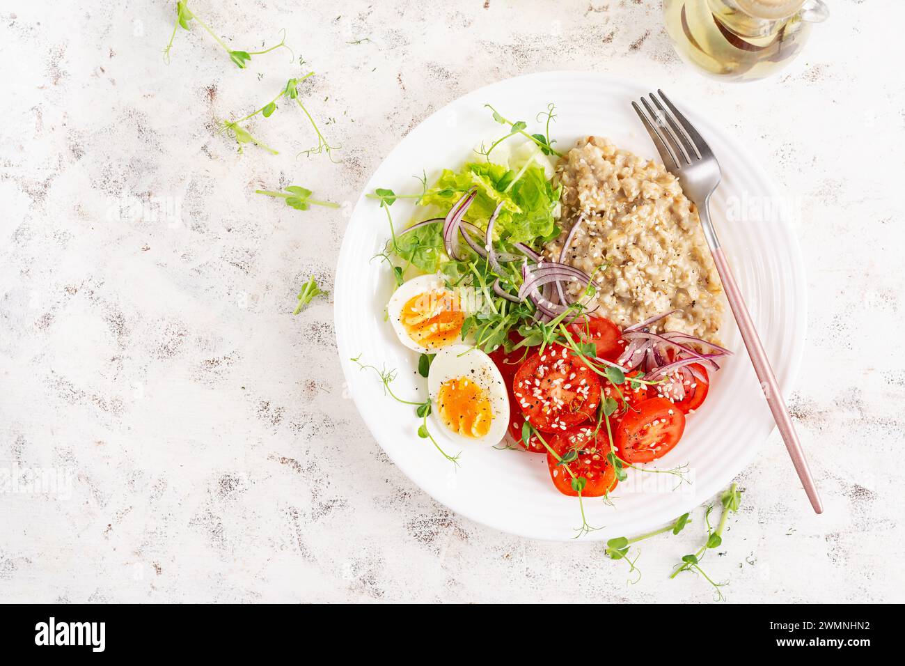 Frühstück Haferbrei mit gekochten Eiern und frischem Gemüse. Gesunde ausgewogene Ernährung. Trendiges Essen. Draufsicht, flach Stockfoto