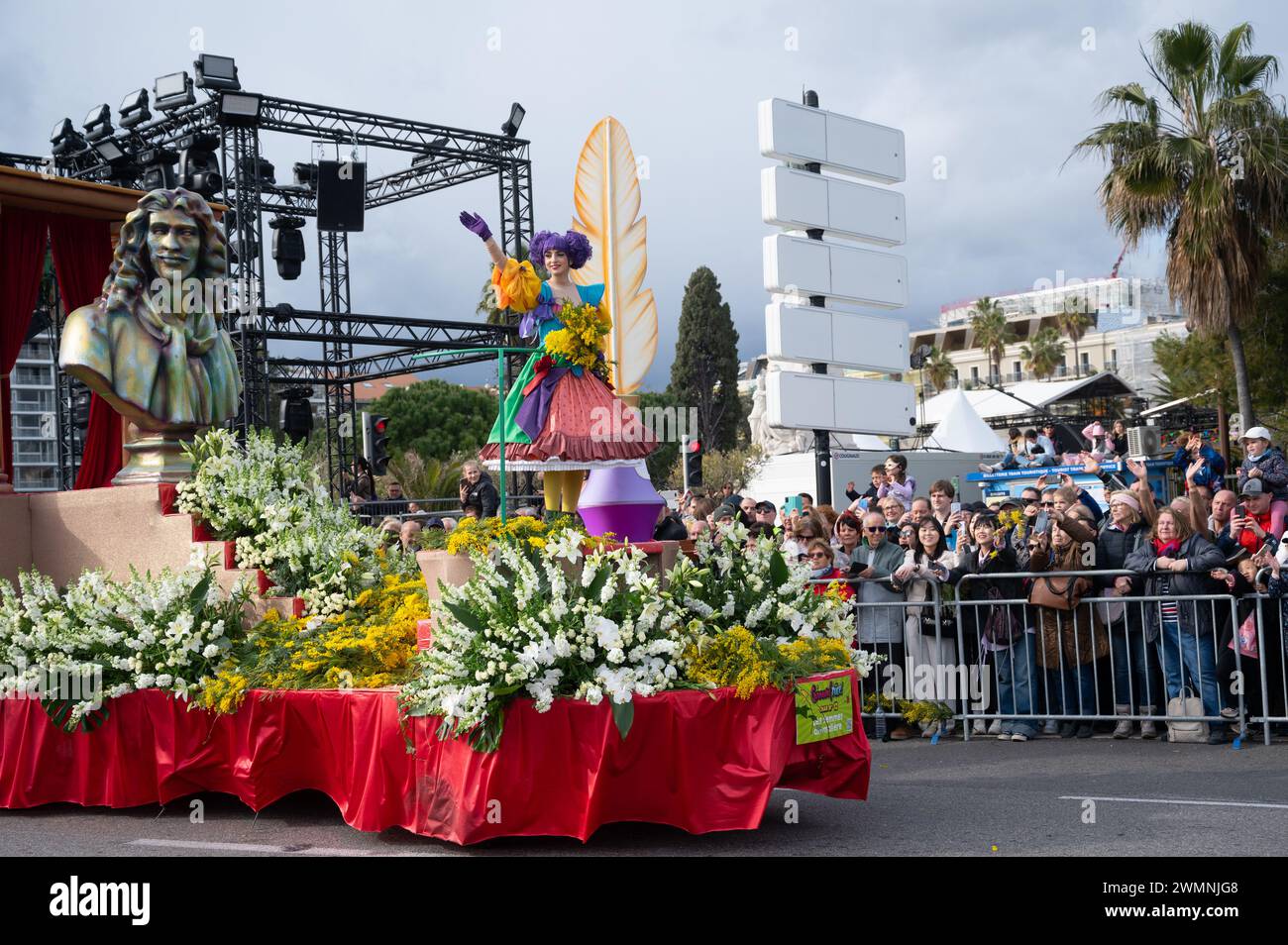 Frauen auf Karnevalswagen werfen Blumen in die Menschenmassen bei der Flower Battle am 24. Februar 2024 in Nizza Stockfoto