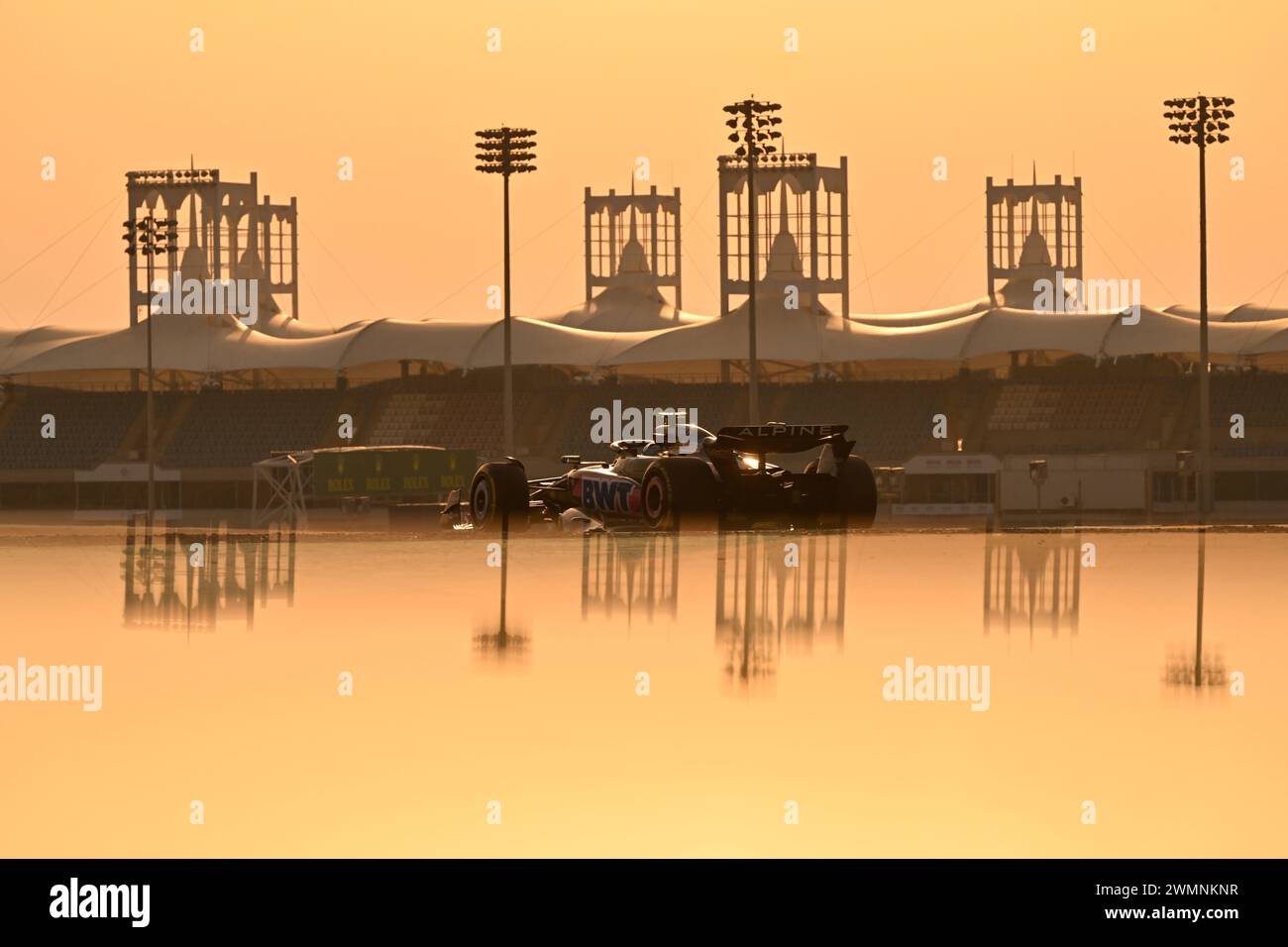 BAHRAIN, Sakhir, 23. Februar: Atmosphäre mit dem Alpine F1-Auto von OCON bei Sonnenuntergang, die Renngebäude spiegeln sich im Wasser während des dritten Tages der F1-Tests auf dem Bahrain International Circuit am 23. Februar 2024 in Bahrain, Formel-1-Tests vor der Saison, Bild & Copyright Jerry ANDRE / ATP Images (ANDRE JERRY/ATP/SPP) Stockfoto