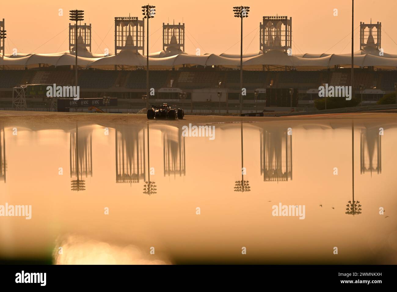 BAHRAIN, Sakhir, 23. Februar: Atmosphäre mit F1-Auto bei Sonnenuntergang, die Renngebäude spiegeln sich im Wasser am dritten Tag der F1-Tests auf dem Bahrain International Circuit am 23. Februar 2024 in Bahrain, Formel-1-Tests vor der Saison, Bild & Copyright Jerry ANDRE / ATP Images (ANDRE Jerry / ATP / SPP) Stockfoto