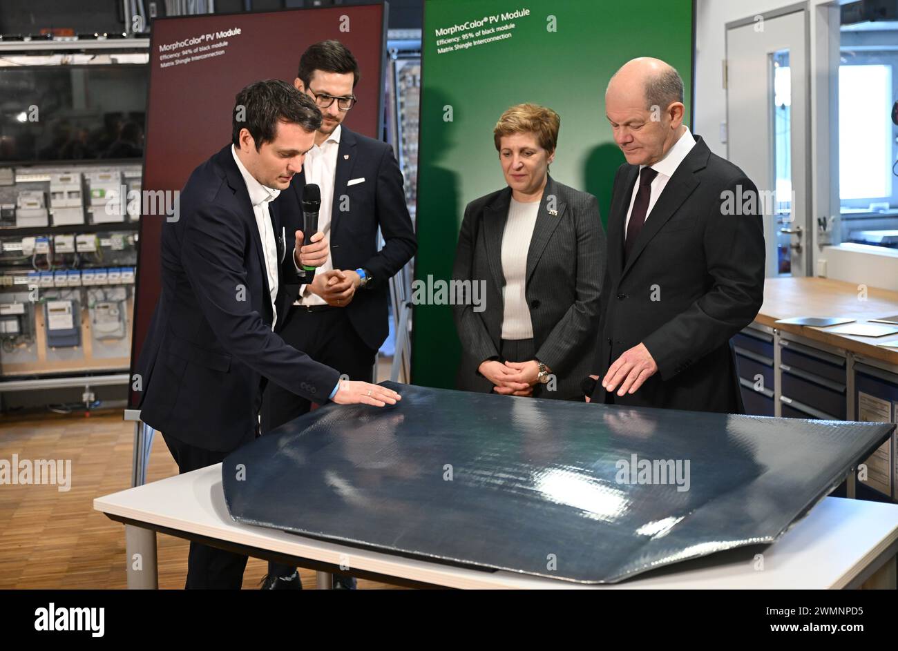 27. Februar 2024, Baden-Württemberg, Freiburg: Martin Heinrich (l) vom Fraunhofer-Institut erklärt Bundeskanzler Olaf Scholz (r) vom Fraunhofer-Institut für Solarenergiesysteme ISE eine mit Solarzellenfolie überzogene Haube. neben Scholz steht Nicole Razavi (CDU, 2. v. R.), Baden-Württembergs Ministerin für Wohn- und Regionalentwicklung. und Martin Horn, Oberbürgermeister von Freiburg. Der Terminplan des Bundeskanzlers für seinen Besuch in Südbaden beinhaltet auch einen Spatenstich für einen neuen Stadtbezirk, einen Besuch im SC Freiburg Stadion mit gesellschaftlich engagiertem Engagement Stockfoto