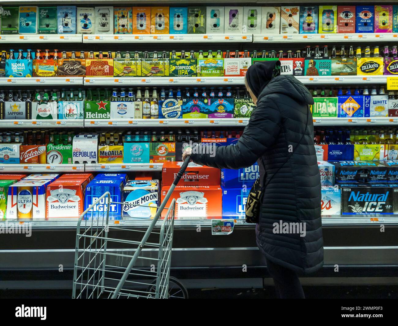 Seniorin stöbert am Donnerstag, den 15. Februar 2024, in einem Supermarkt in New York durch die Bierauswahl. (© Richard B. Levine) Stockfoto