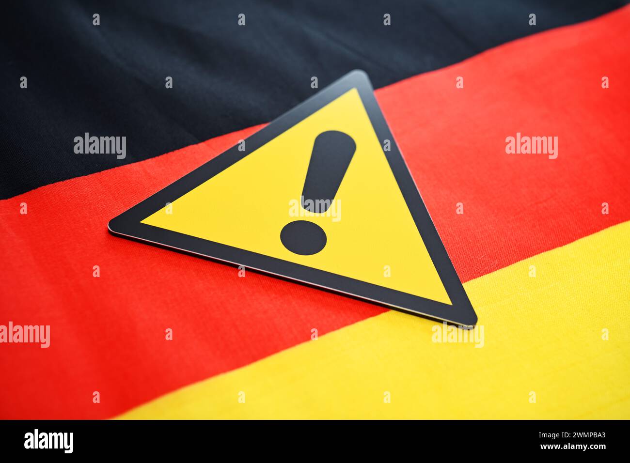 Warnschild auf deutscher Flagge, symbolisches Foto zur Verteidigung der Demokratie gegen Rechtsextremismus Stockfoto